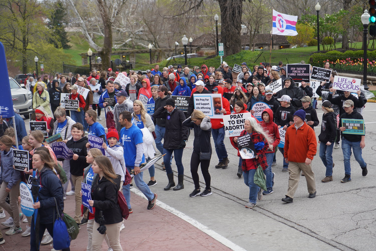 Participants in the 2022 Midwest March for Life in Jefferson City on April 20 give thanks for a break in the rain while marching past the Governor’s Mansion.